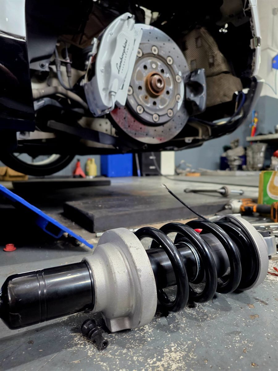 Coilover suspension unit beside a brake disc in the workshop
